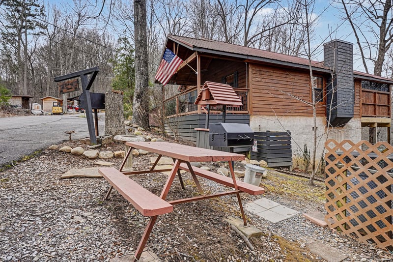 Charming wooden cabin retreat with outdoor dining table and mountain views, perfect for your peaceful getaway.