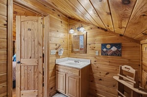 Step into your cozy cabin bathroom where rustic log walls and warm wood details create a mountain retreat atmosphere.