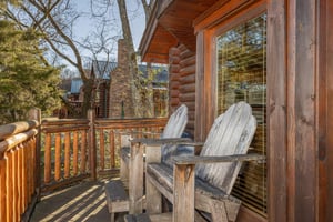 Adirondack chairs on a deck at Gone Fishin, a 2bedroom cabin rental located in Pigeon Forge
