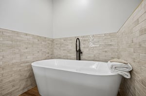 Sink into your private soaking tub surrounded by elegant stone tile—your perfect retreat after a day of exploring.