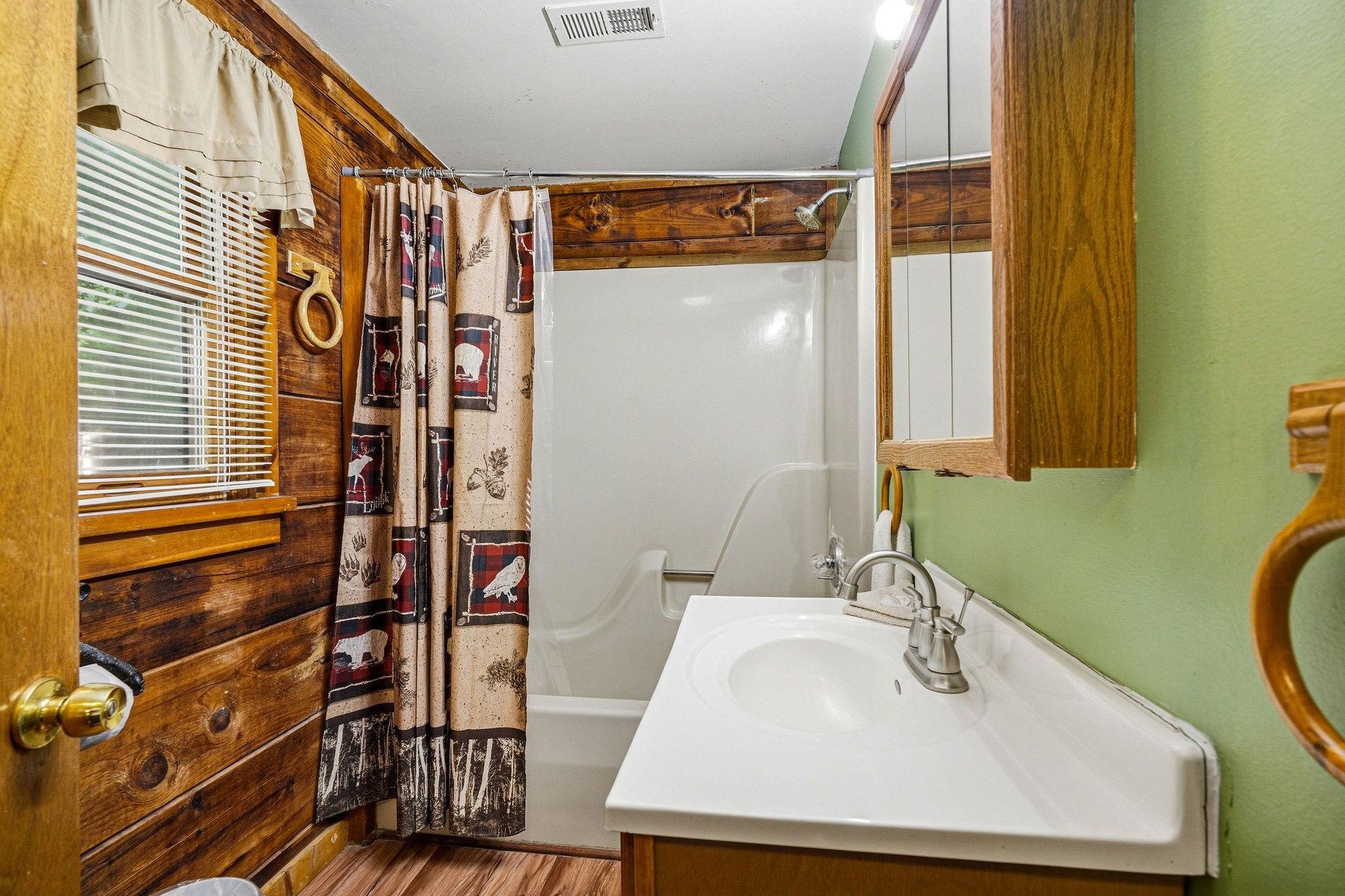 Refresh in your charming cabinstyle bathroom with warm wood accents and rustic charm throughout.