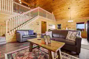 Sink into plush leather sofas surrounded by warm wood walls and rustic charm in your cozy living space.