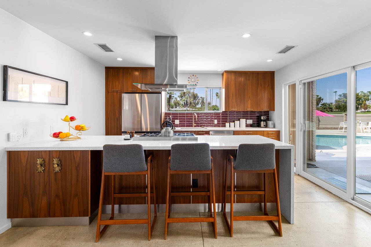 Stainless steel appliances, counter seating for 3, and patio access.