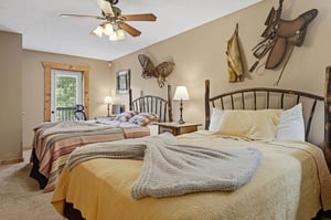Rest easy in your cozy bedroom with rustic charm, featuring two comfy beds and authentic Western decor that invites peaceful sleep after a day of adventure.