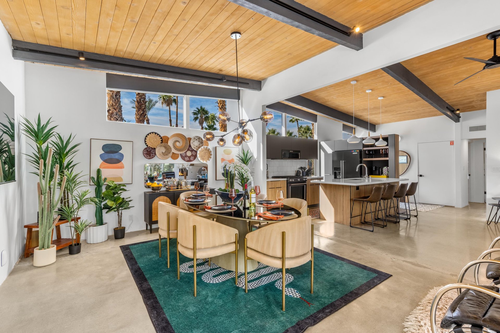 Gather around your stylish dining table beneath stunning exposed beams, while the open kitchen invites culinary adventures with tropical palm views.
