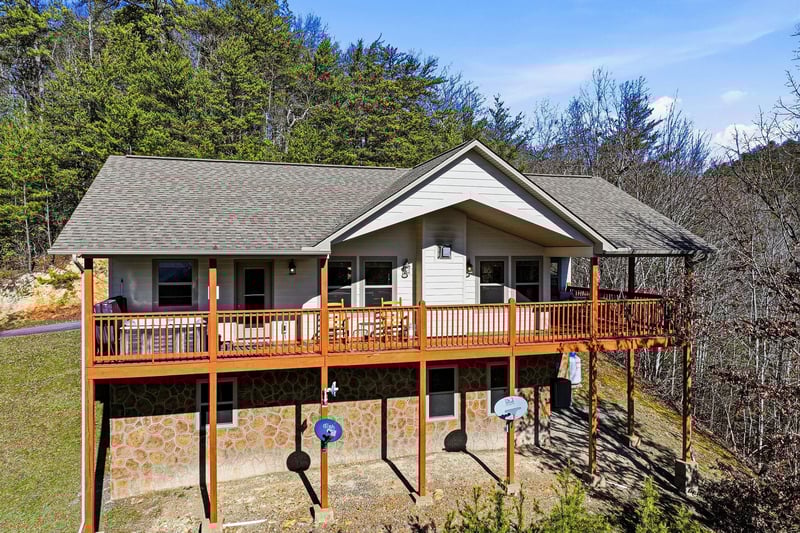 Modern mountain retreat with spacious decks and forest backdrop, perfect for a peaceful getaway.
