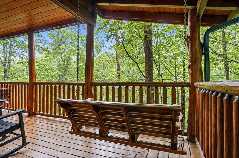 Imagine unwinding on your covered terrace, swaying on the porch swing while surrounded by tranquil forest views—your peaceful retreat awaits.