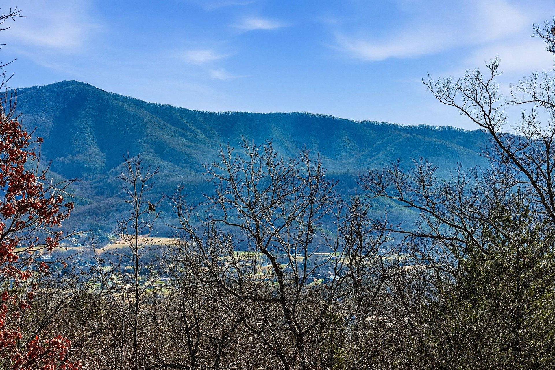 Mountain views stretch across the valley with forested hills and clear blue skies in this scenic location.