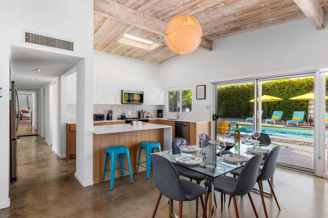 Your openconcept kitchen flows seamlessly to the dining area, where poolside views through floortoceiling windows create the perfect backdrop for meals together.