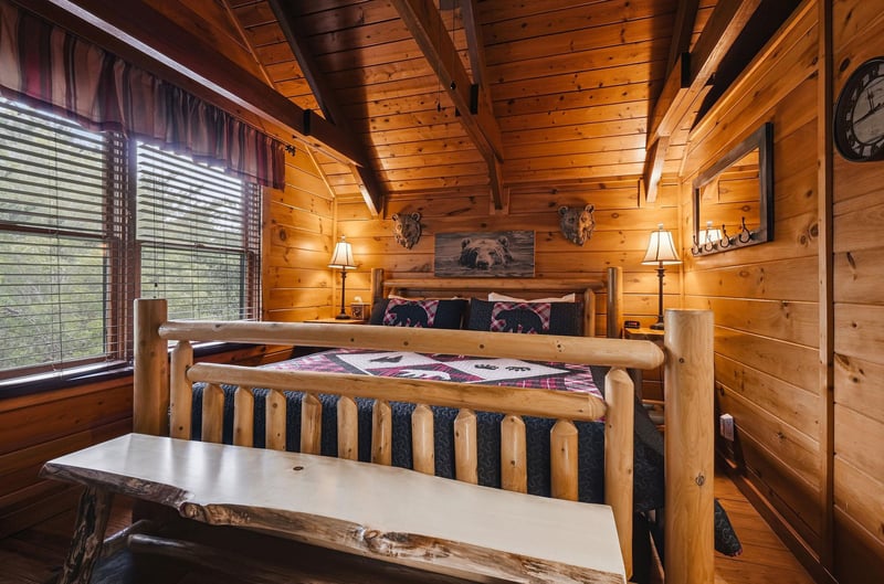 Unwind in this cozy log cabin bedroom, where rustic charm meets comfort. Your handcrafted log bed invites restful nights under the warmth of knotty pine ceilings and beams.