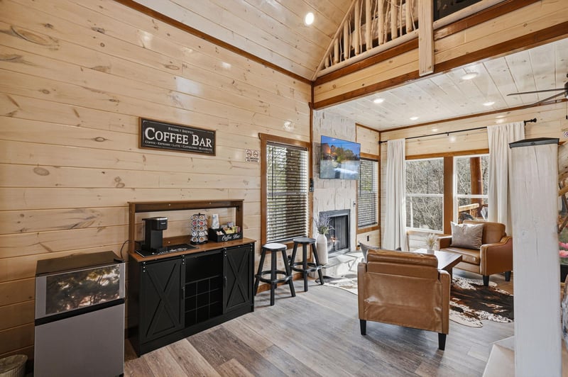 Unwind in your cozy living space with warm wood walls, leather seating, and a dedicated coffee station for perfect mornings.