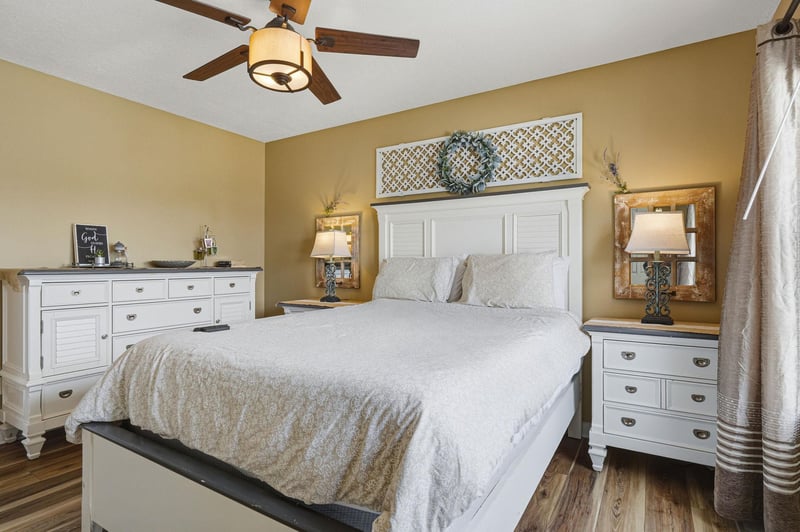 Your peaceful retreat awaits with a plush bed, calming décor, and gentle breezes from the ceiling fan overhead. Warm tones and soft lighting create a serene sanctuary for restful nights.