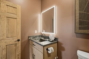 Freshen up in your modern bathroom featuring a vanity with granite countertop and LEDlit mirror.