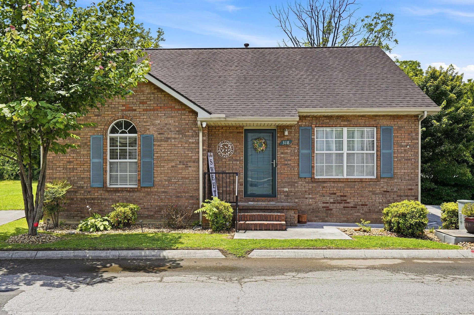 A charming brick ranchstyle home with classic shutters, a welcoming front entrance, and beautifully maintained landscaping that greets you upon arrival.