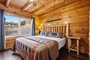 Drift off to sleep in your cozy log cabin bedroom, wrapped in rustic charm with handcrafted wooden furnishings and wildlifethemed bedding.