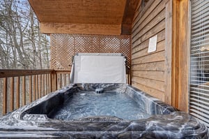 Soak your worries away in your private hot tub on this cozy wooden deck, surrounded by peaceful forest views.