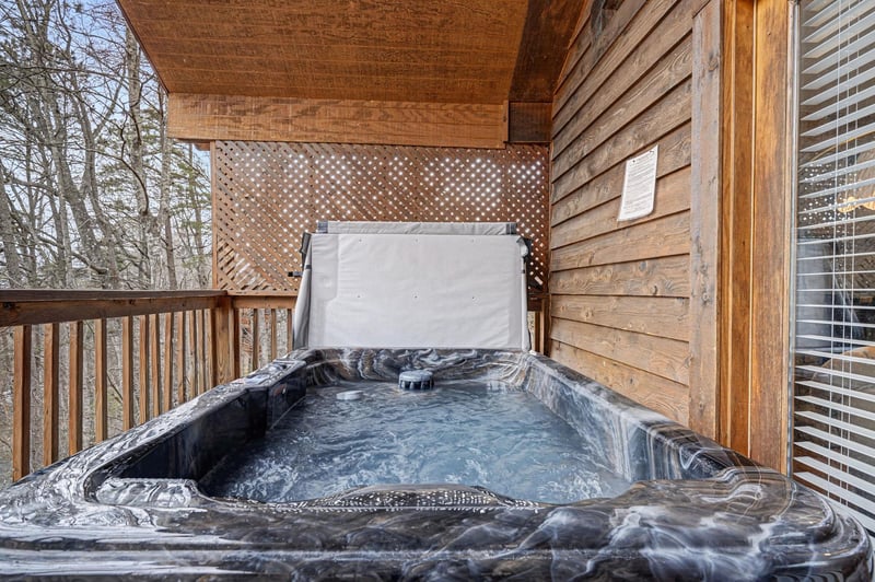 Soak your worries away in your private hot tub on this cozy wooden deck, surrounded by peaceful forest views.