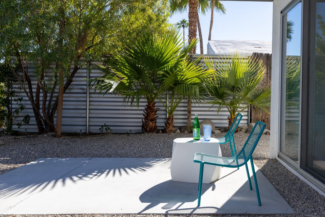 Step onto your private patio where tropical palms create perfect shade for afternoon relaxation with refreshing drinks.