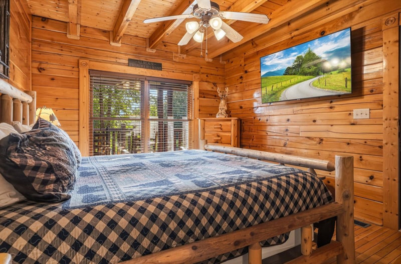 Drift into restful sleep in your cozy logwalled bedroom, where rustic timber beams soar overhead and plaid bedding invites you to unwind after a day of adventure.