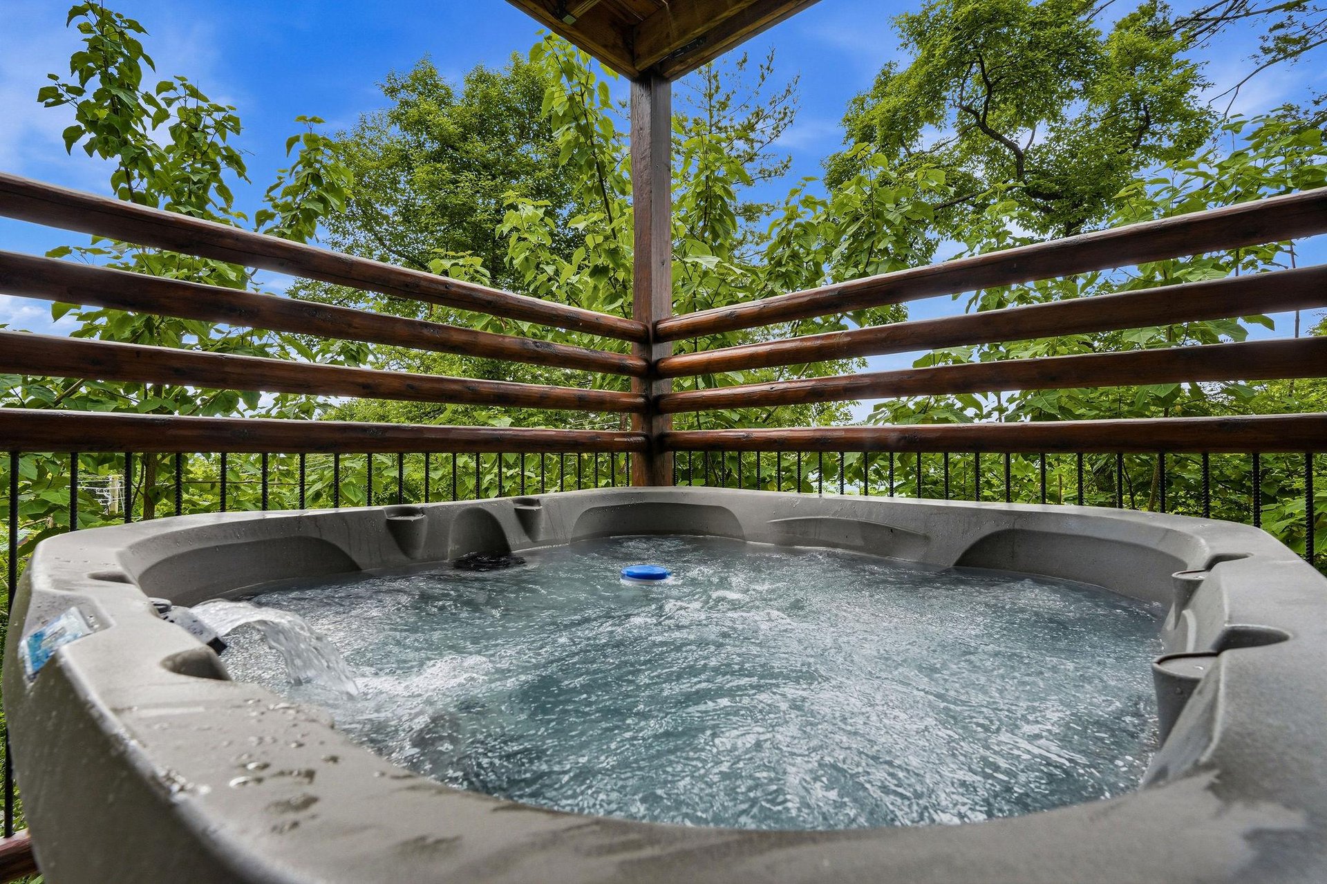 Soak in the bubbling hot tub on your private balcony, surrounded by lush greenery and open sky—your perfect escape for relaxation and tranquility.