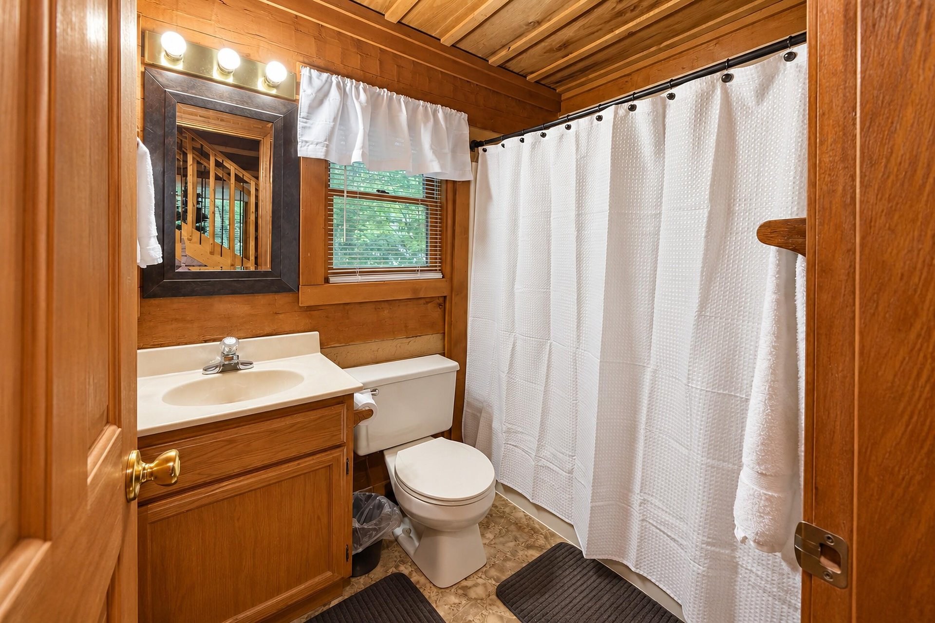 Step into your cozy cabinstyle bathroom, where warm wood tones and natural light create a serene retreat after a day of adventure.