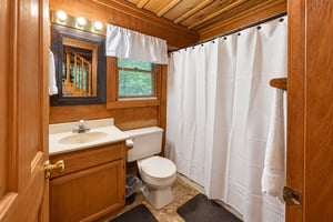 Step into your cozy cabinstyle bathroom, where warm wood tones and natural light create a serene retreat after a day of adventure.