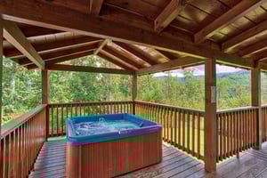 Hot tub on a covered deck at Four Seasons Lodge, a 3bedroom cabin rental located in Pigeon Forge