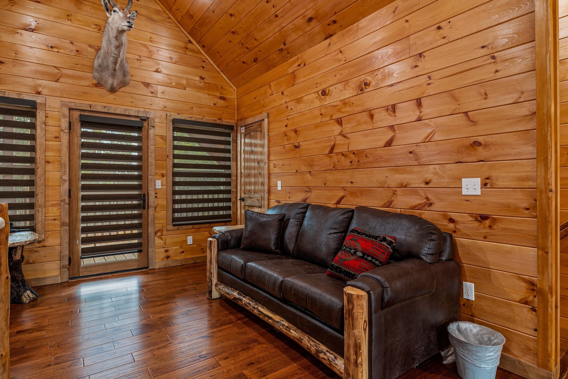 Leather couch in game room at Four Seasons Grand, a 5 bedroom cabin rental located in Pigeon Forge