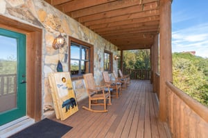Deck with bean bag game and rocking chairs at Great View Lodge, a 5bedroom cabin rental located in Pigeon Forge
