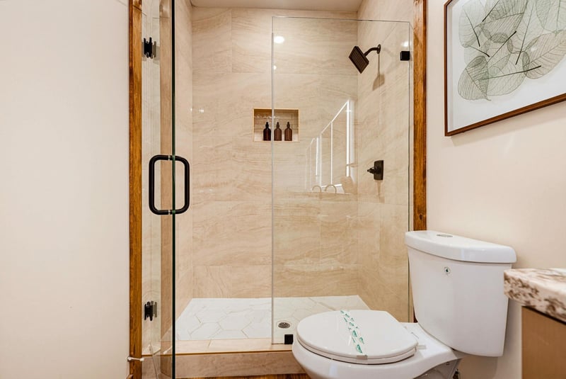 Freshen up in your modern spainspired bathroom, featuring a beautifully tiled walkin shower with sleek glass doors and premium amenities.