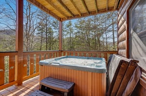 Soak in your private hot tub under the covered deck, surrounded by peaceful forest views and mountain serenity.
