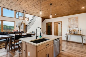 Relax under soaring wood ceilings while preparing meals at your island sink and enjoying sweeping mountain views through floortoceiling windows—your peaceful retreat blends rustic charm with modern 