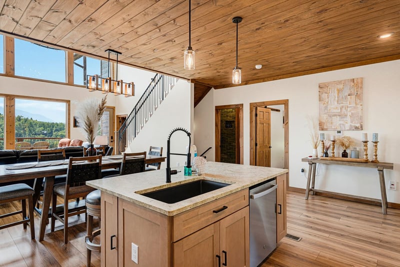 Relax under soaring wood ceilings while preparing meals at your island sink and enjoying sweeping mountain views through floortoceiling windows—your peaceful retreat blends rustic charm with modern 