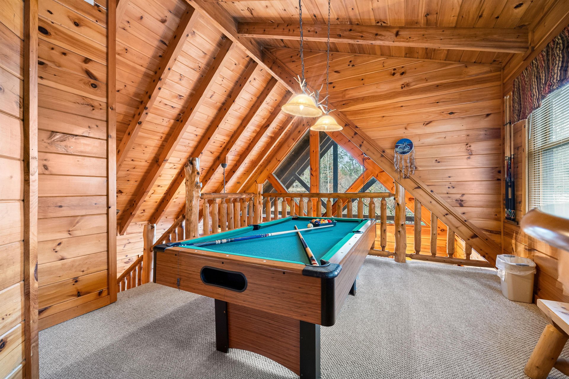 Your private game loft awaits with a fullsize pool table beneath soaring log cabin beams, perfect for friendly competition and mountain memories.