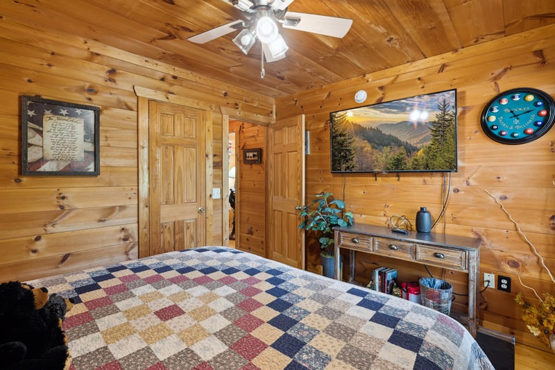 King bed facing table with drawers and tv