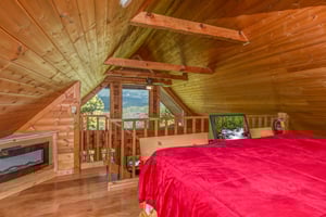 Fireplace and mountain view in the loft bedroom at Cupids Crossing, a 1 bedroom cabin rental located in Pigeon Forge