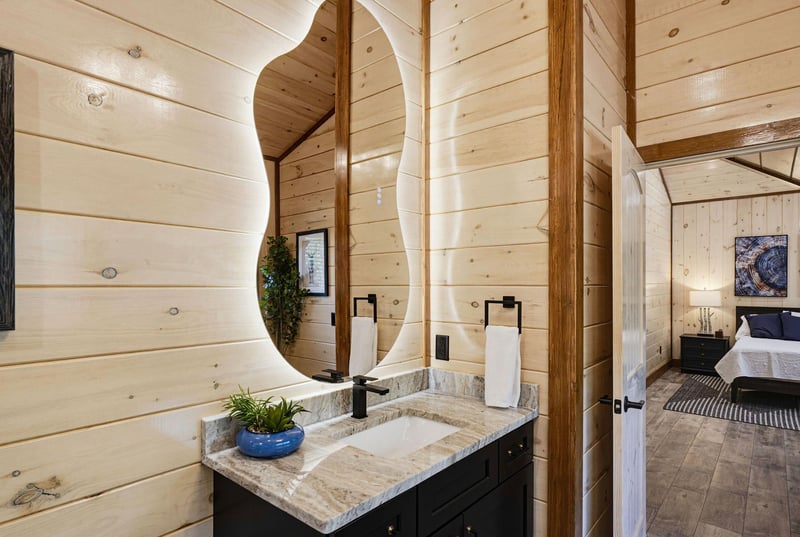 Step into your private suite featuring warm woodpaneled walls and a stylish vanity area with modern fixtures, leading directly to your comfortable bedroom retreat.