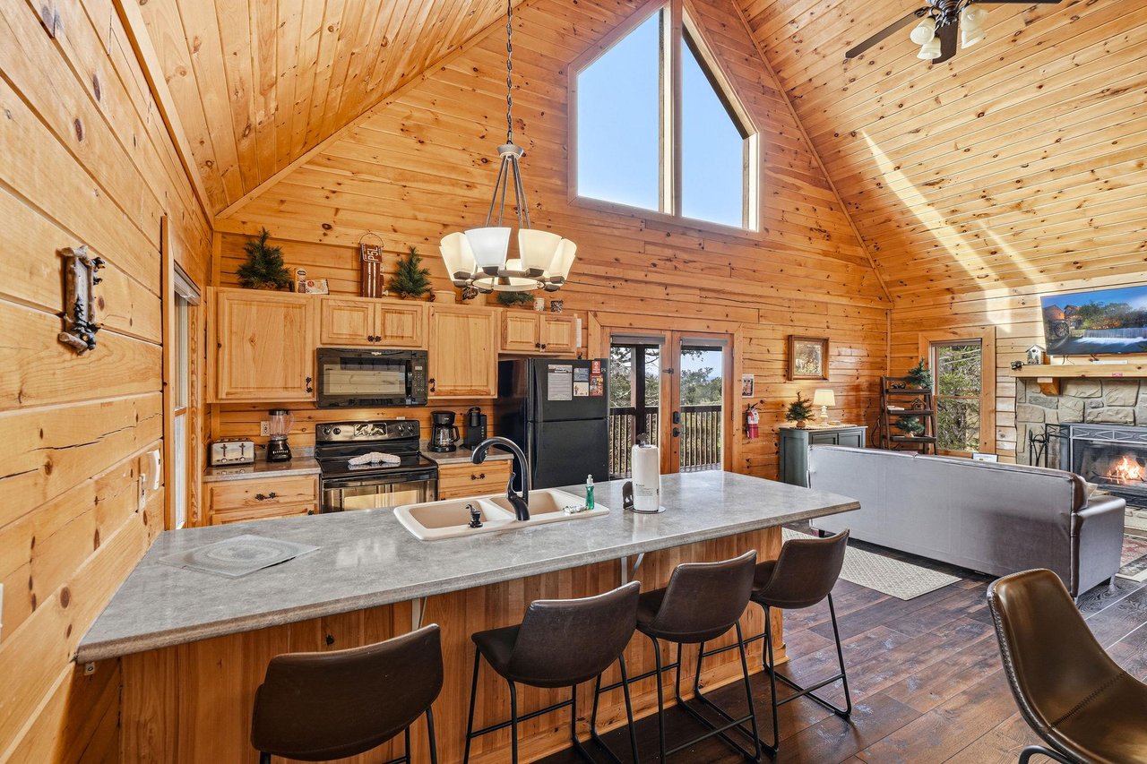 Gather around your spacious kitchen island where rustic charm meets modern convenience in this stunning log cabin retreat.