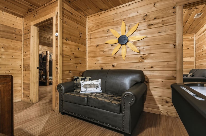 Settle into your cozy leather loveseat surrounded by warm cedar walls and charming handcrafted décor that makes this rustic retreat feel like home.