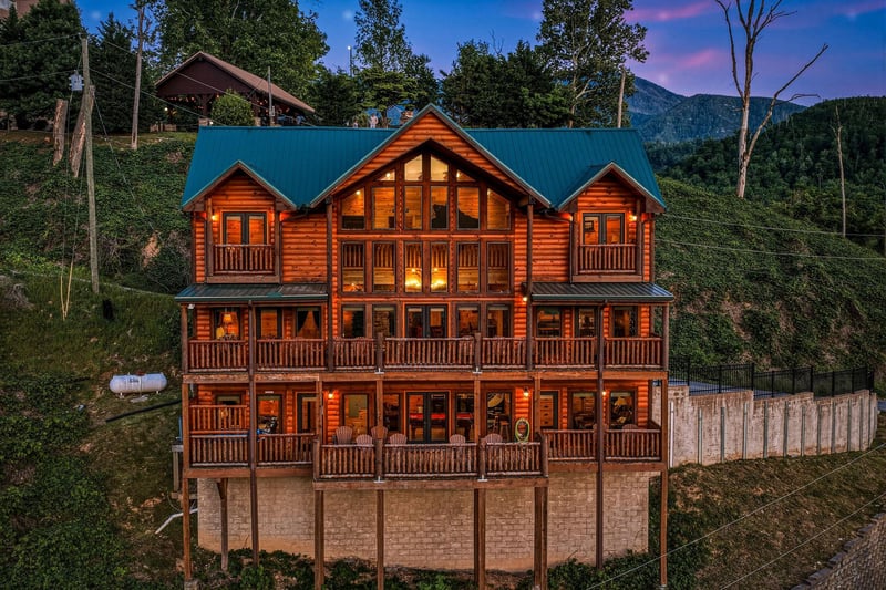 This stunning log cabin sits nestled against forested mountains, offering a serene mountain retreat. Multiple balconies and expansive windows invite natural light and breathtaking views throughout you