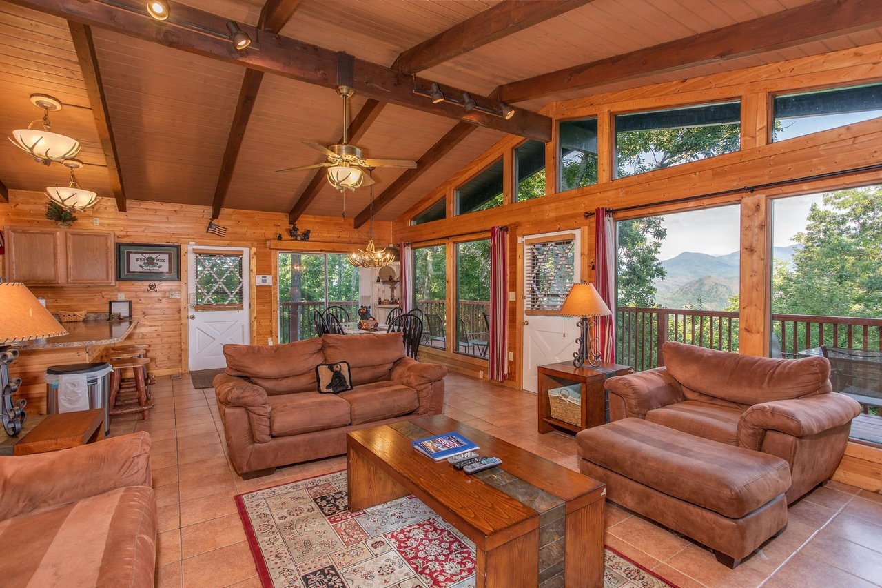 Vaulted living room with floortoceiling windows at Bushwood Lodge, a 3bedroom cabin rental located in Gatlinburg