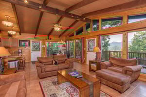 Vaulted living room with floortoceiling windows at Bushwood Lodge, a 3bedroom cabin rental located in Gatlinburg