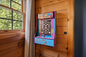 Challenge friends to classic PacMan in your private gaming nook, where nostalgic fun meets cozy cabin charm.