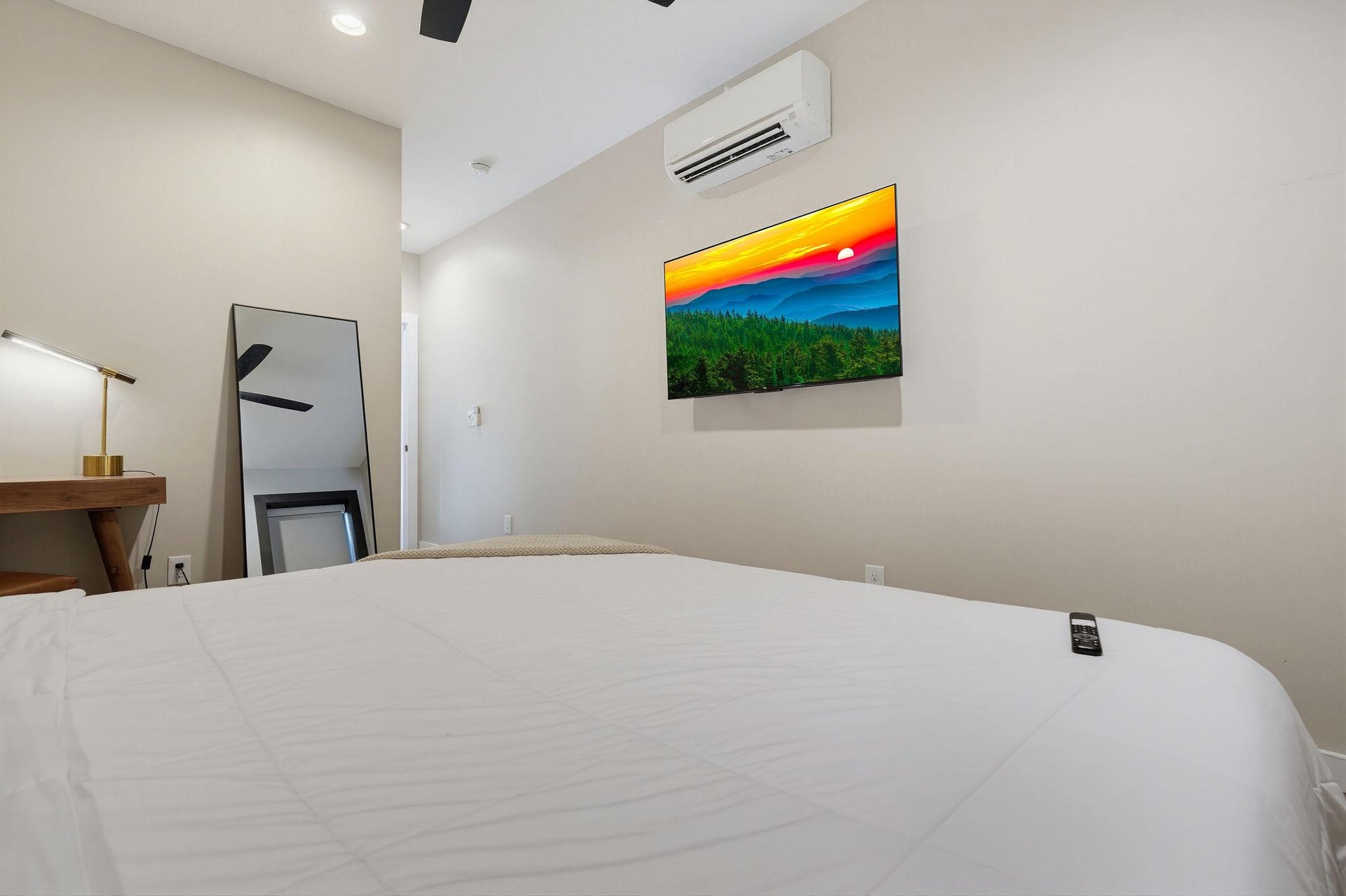 Your bright, modern bedroom features climatecontrolled comfort and a crisp, inviting bed that promises restful nights. A perfect retreat after exploring the area.