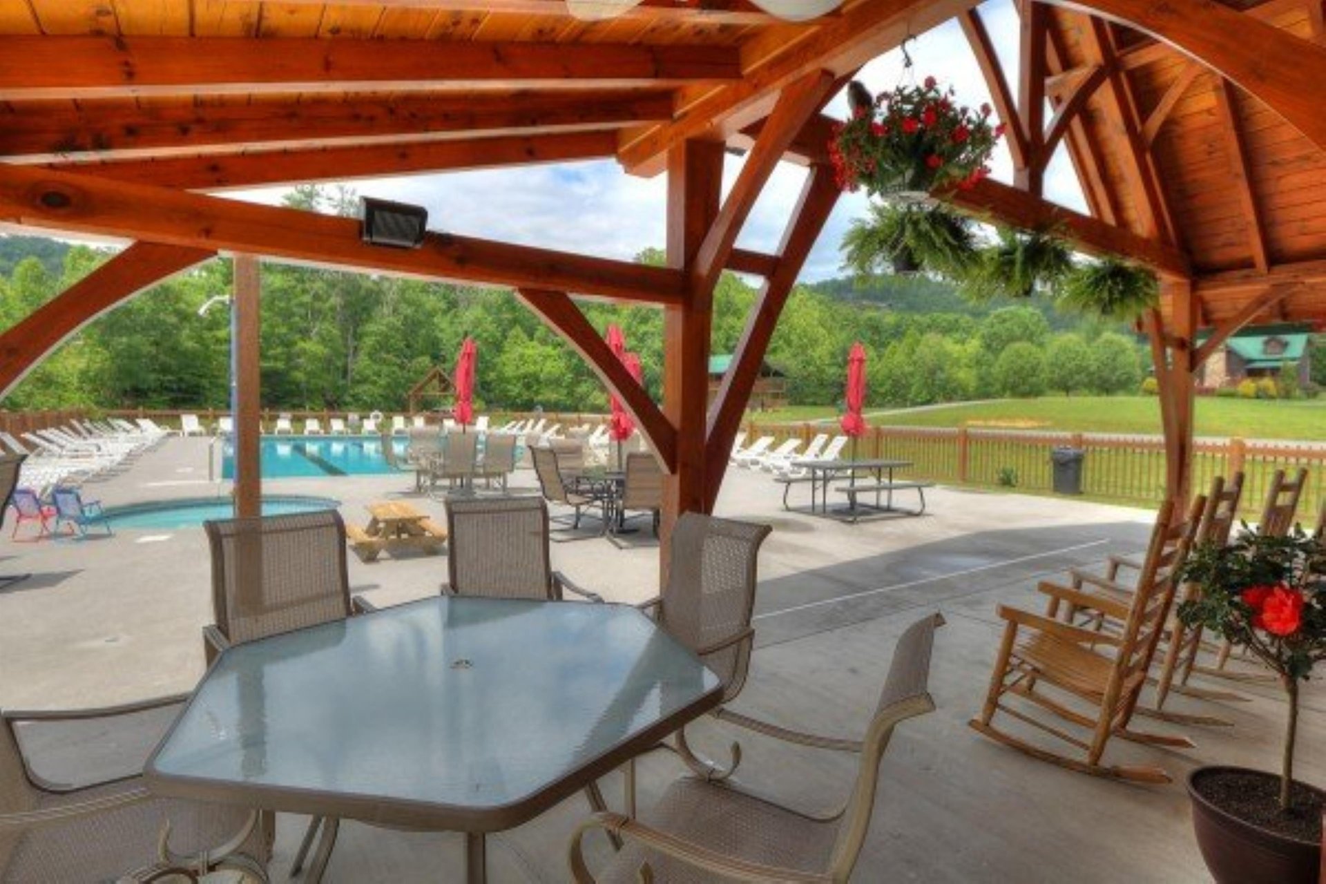 Relax in this inviting covered patio with poolside seating, where you can unwind surrounded by lush mountain views and enjoy the tranquil outdoor space.