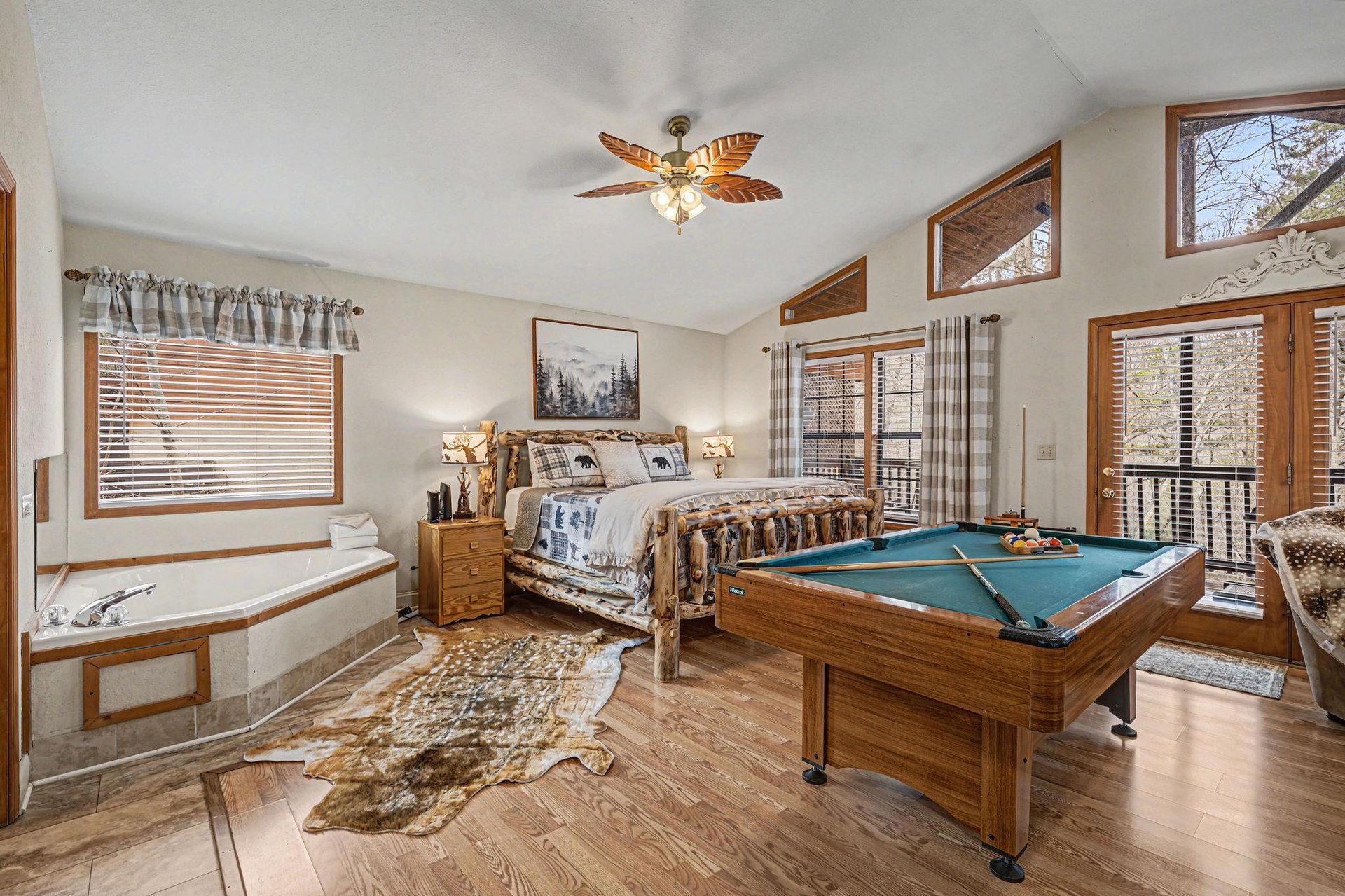 Your master bedroom combines comfort with entertainment—relax in the king bed or challenge friends to pool while enjoying forest views.
