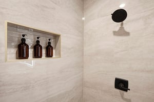 Step into your beautifully appointed shower with elegant marblestyle tile, matte black fixtures, and premium toiletries ready for your comfort.