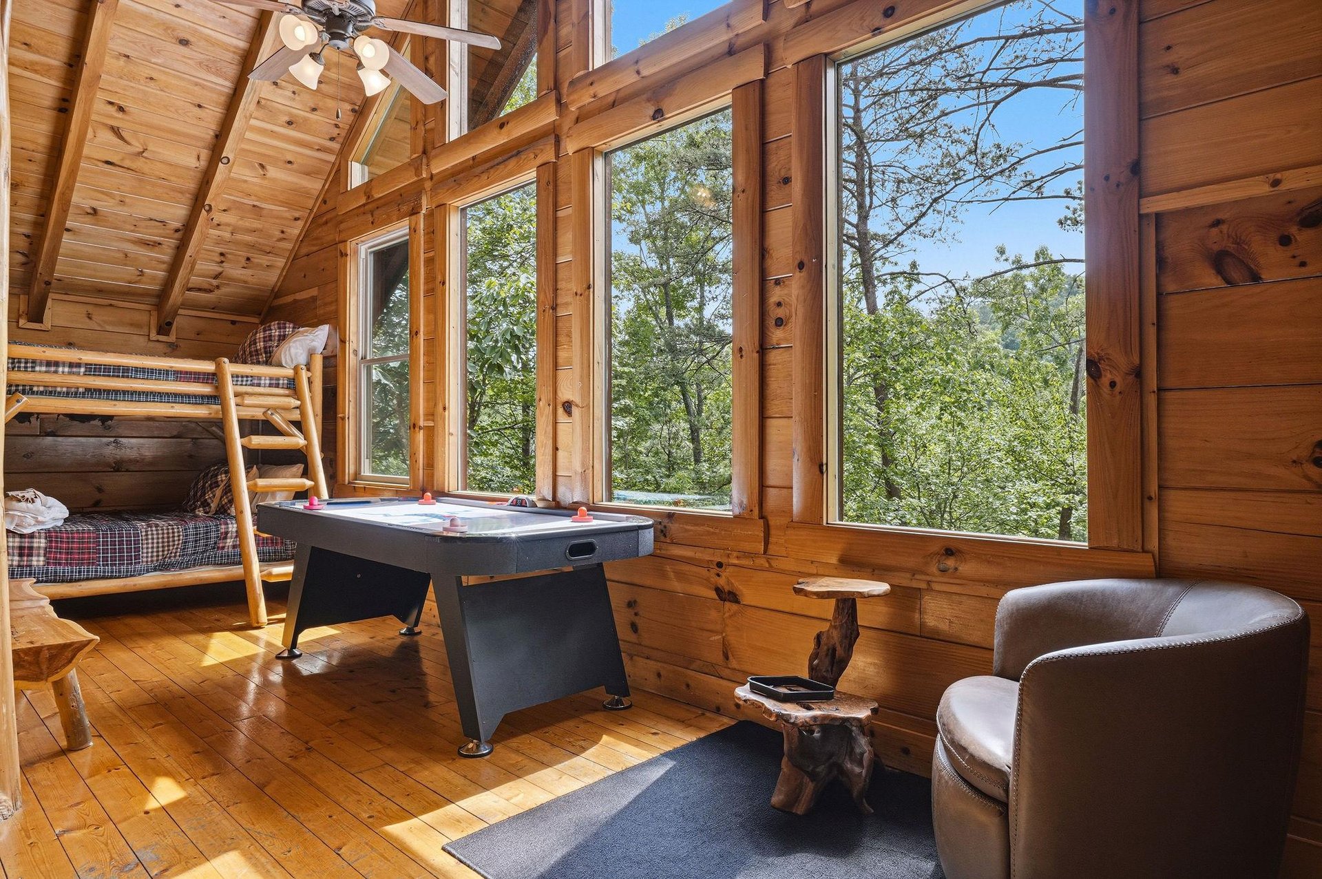 Gather with loved ones in this sunlit game room, where bunk beds and an air hockey table set the stage for friendly competition and laughter beneath soaring wood ceilings.
