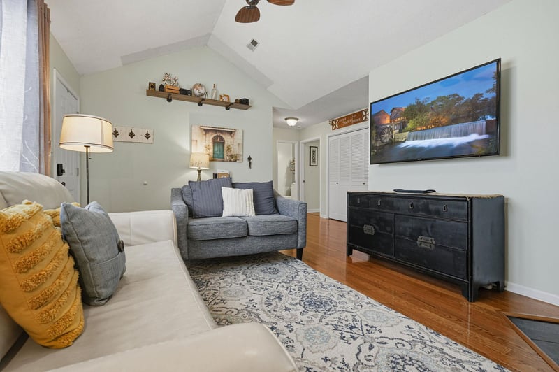 Sink into the plush sofa and unwind in this bright, vaulted living room. Catch your favorite shows on the big screen, or simply relax with a book beneath the warm glow of the floor lamp.