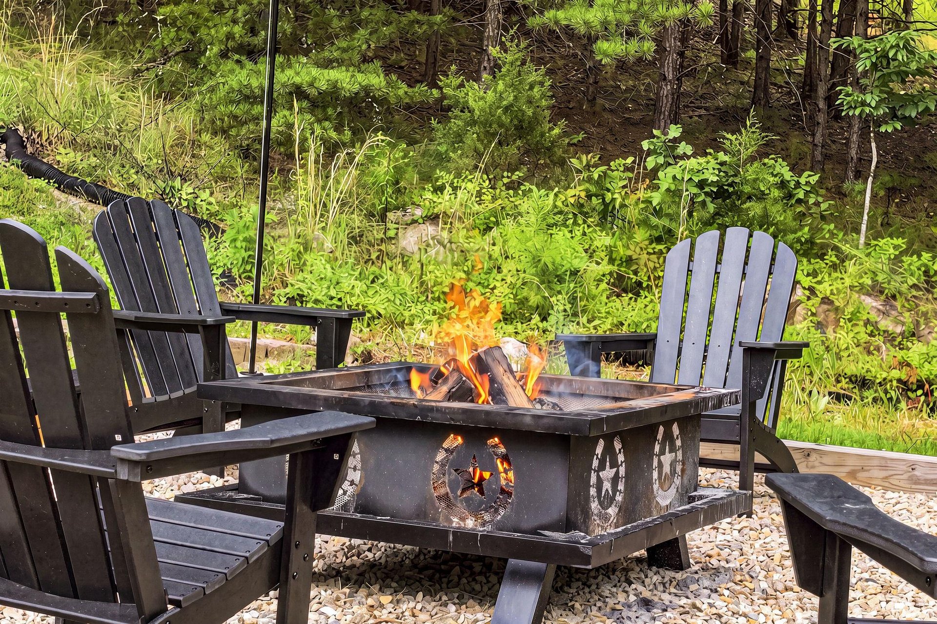 Gather around the crackling fire under the open sky, where Adirondack chairs invite you to unwind and soak in the peaceful forest surroundings.